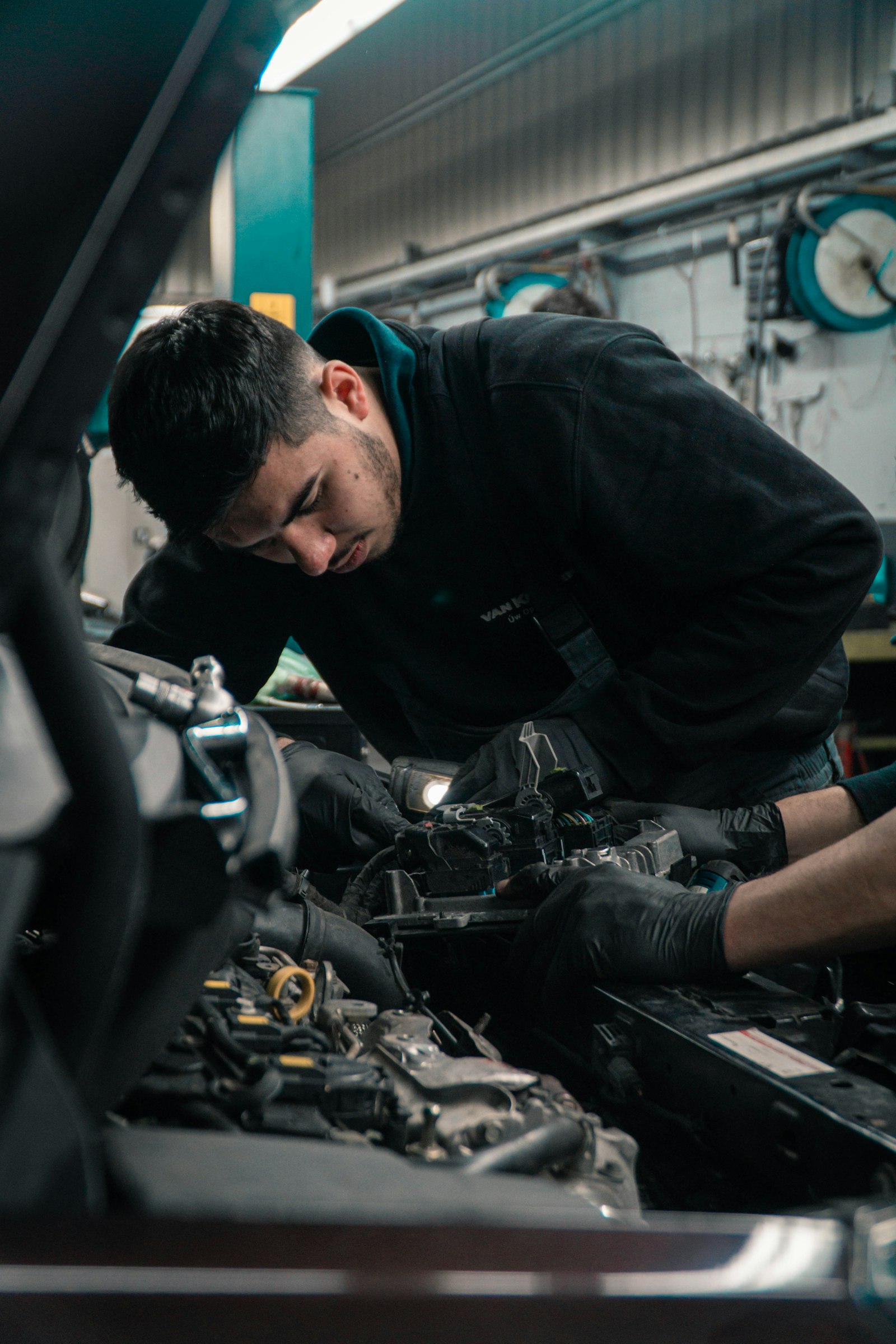 Technician inspecting a vehicle engine bay